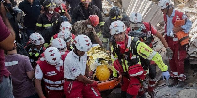 A survivor is pulled out of the rubble in Amatrice, central Italy, where a 6.1 earthquake struck just after 3:30 a.m., Wednesday, Aug. 24, 2016. The quake was felt across a broad section of central Italy, including the capital Rome where people in homes in the historic center felt a long swaying followed by aftershocks. (AP Photo/Emilio Fraile)
