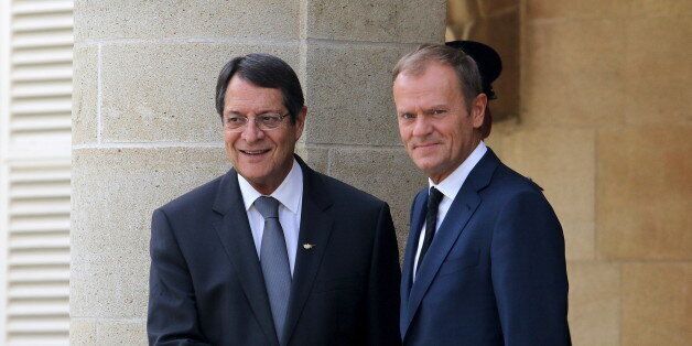 Cypriot President Nicos Anastasiades (L) and European Council President Donald Tusk shake hands at the presidential palace in Nicosia, Cyprus September 11, 2015. REUTERS/Yiannis Kourtoglou
