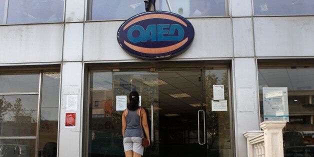 A woman stands outside a Greek Manpower Employment Organisation (OAED) office in a northern suburb of Athens September 12, 2013. Greece's jobless rate rose to 27.9 percent in June from 27.6 percent in May, reflecting the impact of a six-year, austerity-fuelled recession, the country's statistics service ELSTAT said on Thursday. REUTERS/John Kolesidis (GREECE - Tags: POLITICS BUSINESS EMPLOYMENT)