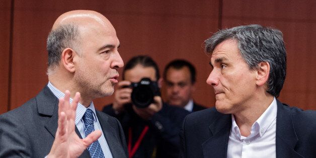 EU Commissioner for Economic and Financial Affairs, Taxation and Customs Pierre Moscovici, left, talks with Greece's Finance Minister Euclid Tsakalotos ahead of an EU eurogroup meeting at the EU Council building in Brussels on Monday May 9, 2016. European finance ministers gathered in Brussels Monday for talks aimed at breaking the deadlock over whether to provide more aid to bolster Greece's shattered economy and forgive some of its debts. (AP Photo/Geert Vanden Wijngaert)