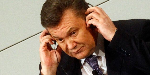 Ukrainian President Viktor Yanukovych adjusts his earphones during the 48th Conference on Security Policy in Munich February 3, 2012. REUTERS/Michael Dalder(GERMANY - Tags: POLITICS)
