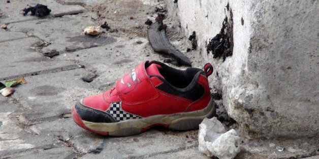 The shoe of a young victim and a piece of metal lay near the scene just hours after Saturday's bomb attack in Gaziantep, southeastern Turkey, early Sunday, Aug. 21, 2016, targeting an outdoor wedding party in southeastern Turkey killing dozens of people and wounding dozens more. Deputy Prime Minister Mehmet Simsek said the
