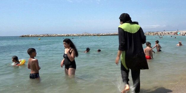 FILE - In this Aug.4 2016 file photo made from video, Nissrine Samali, 20, gets into the sea wearing traditional Islamic dress, in Marseille, southern France. The French resort of Cannes has banned full-body, head-covering swimsuits worn by some Muslim women from its beaches, citing security concerns. A City Hall official said the ordinance, in effect for August, could apply to burkini-style swimsuits. (AP Photo, File)