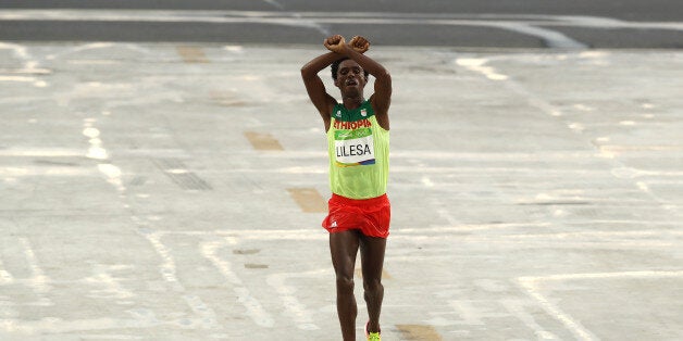 RIO DE JANEIRO, BRAZIL - AUGUST 21: Feyisa Lilesa of Ethiopia celebrates as he crosses the line to win silver during the Men's Marathon on Day 16 of the Rio 2016 Olympic Games at Sambodromo on August 21, 2016 in Rio de Janeiro, Brazil. (Photo by Buda Mendes/Getty Images)