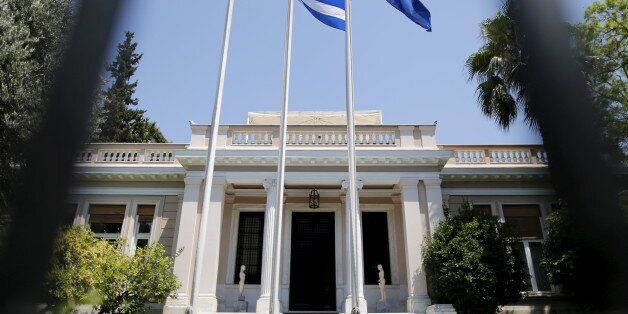 The Greek (L) and the European Union flags flutter in front of Maximos Mansion, the Prime Minister offices, in Athens, Greece, July 13, 2015. Euro zone leaders made Greece surrender much of its sovereignty to outside supervision on Monday in return for agreeing to talks on an 86 billion euros bailout to keep the near-bankrupt country in the single currency. REUTERS/Christian Hartmann