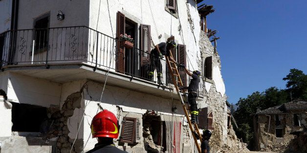 Firefighters recover personal belongings from a damaged house in the village of San Lorenzo a Flaviano, central Italy, Sunday, Aug. 28, 2016. Bulldozers with huge claws pulled down dangerously overhanging ledges Sunday in Italy's quake-devastated town of Amatrice as investigators worked to figure out if negligence or fraud in building codes had added to the quake's high death toll. (AP Photo/Andrew Medichini)