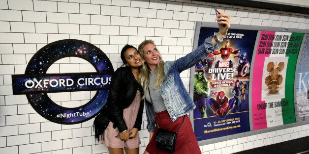 Passengers pose for a selfie as they wait for the Night Tube train service at Oxford Circus on the London underground system in London, Britain August 20, 2016. REUTERS/Paul Hackett TPX IMAGES OF THE DAY