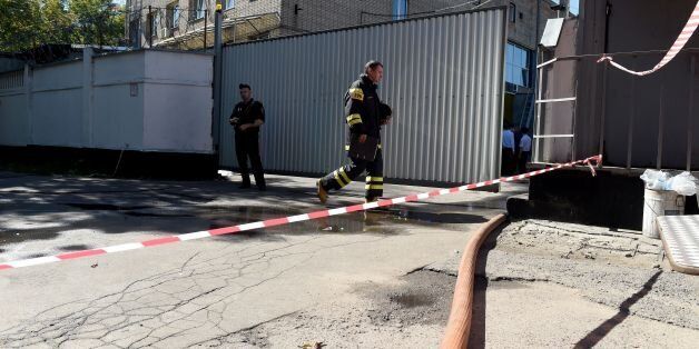 Firefighters work at the site of a fire in a Moscow warehouse on August 27, 2016.At least 16 migrant workers died in a fire that broke out at a Moscow warehouse on August 27, 2016 morning, Russian authorities said. The head of the Moscow branch of the emergency ministry, Ilya Denisov, told Russian news agencies that the victims of the fire were migrant workers from Kyrgyzstan. A criminal investigation was launched to determine whether the blaze erupted due to arson or negligence. / AFP / VASILY