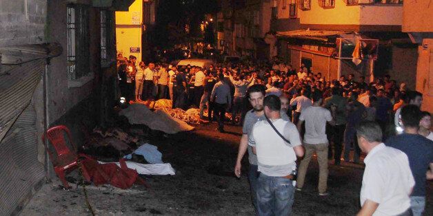 People gather after an explosion in Gaziantep, southeastern Turkey, early Sunday, Aug. 21, 2016. Gaziantep Province Gov. Ali Yerlikaya said the deadly blast, during a wedding near the border with Syria, was a terror attack. (Eyyup Burun/DHA via AP)e