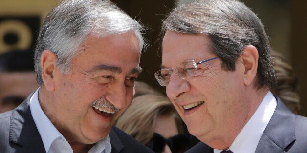 Cyprus' President Nicos Anasatsiades, right, and Turkish Cypriot leader Mustafa Akinci shake hands before joining Greek and Turkish Cypriot children inside the UN controlled buffer zone at Ledras palace crossing point in divided capital Nicosia in east Mediterranean island of Cyprus, Thursday, June, 2, 2016. Anastasiades and Akinci met with 100 fifth-grade Greek and Turkish Cypriot students - 50 from either community - to underscore their commitment to reaching an accord that will reunify the island. (AP Photo/Petros Karadjias)