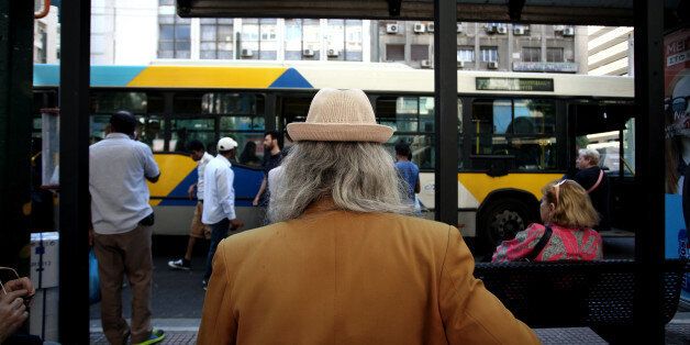 Man wearing a hat waits at the bus station, Athens, May 25, 2016 (Photo by Giorgos Georgiou/NurPhoto via Getty Images)