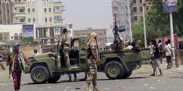 Soldiers and people gather at the site of an attack by a suicide bomber who drove a car laden with explosives into a compound run by local militias in the southern port city of Aden, Yemen August 29, 2016. REUTERS/Fawaz Salman