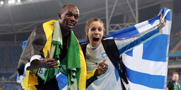 Gold medalist in the men's 4x100-meter relay final Jamaica's Usain Bolt celebrates with gold medalist in the women's pole vault Greece's Ekaterini Stefanidi during the athletics competitions of the 2016 Summer Olympics at the Olympic stadium in Rio de Janeiro, Brazil, Friday, Aug. 19, 2016. (AP Photo/Lee Jin-man)
