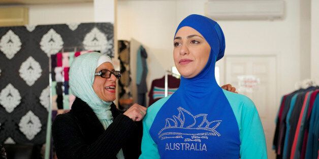 Aheda Zanetti (L), designer of the Burkini swimsuit, adjusts one of the swimsuits on model Salwa Elrashid at her fashion store in Sydney, August 23, 2016. REUTERS/Jason Reed