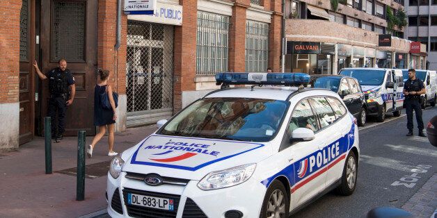A police car parks outside the Rempart Saint-Etienne police station where a police officer has been wounded by a knife-wielding assailant, Tuesday, Aug. 30 2016 in Toulouse, southwestern France. The officer had a minor neck injury and ad the attacker had been arrested. (AP Photo/Fred Lancelot)