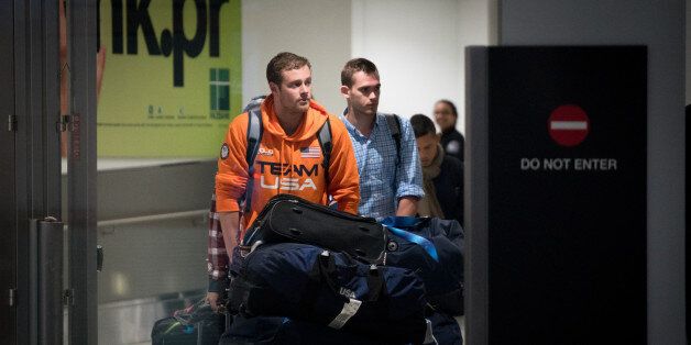 MIAMI, FL - AUGUST 19: USA National Swimming Team members Jack Conger (L) and Gunnar Bentz are escorted through the International terminal at Miami International Airport upon their arrival to the United States from Rio de Janeiro, Brazil on August 19, 2016 in Miami, Florida. Ryan Lochte, Gunnar Bentz, Jack Conger and Jimmy Feigen were involved in an altercation at a gas station in Rio on Sunday. Bentz and Conger were detained by Brazilian authorities while attempting to fly out of Brazil on August 17. Their claims of being victims of a late-night robbery are being questioned by police. (Photo by Angel Valentin/Getty Images)