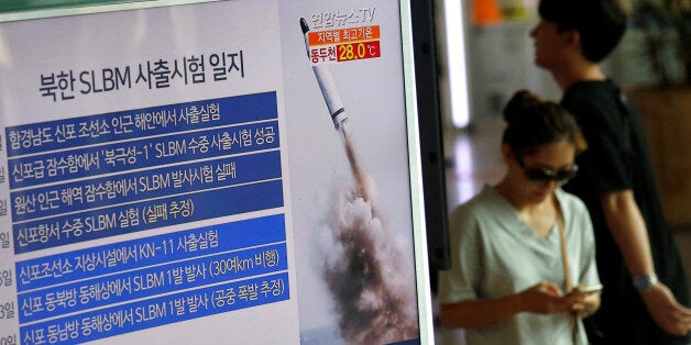 Passengers walk past a TV screen broadcasting a news report on North Korea's submarine-launched ballistic missile fired from North Korea's east coast port of Sinpo, at a railway station in Seoul, South Korea, August 24, 2016 REUTERS/Kim Hong-Ji