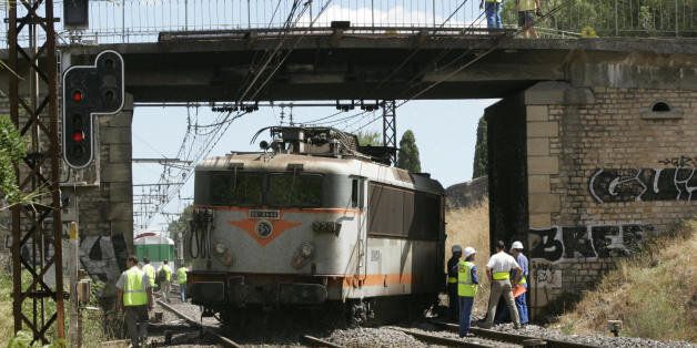 Vergeze, FRANCE: French state rail company SNCF employees work on the track, 03 August 2006 in Vergeze after a train was derailed when it hit donkeys that had wandered onto the track. The suspension between the towns of Nimes and Montpellier will seriously disrupt rail links on the major route between the southwestern city of Bordeaux and Nice on the southeastern Mediterranean coast, as well as high-speed TGV services from Paris and Lille in the north to Montpellier. SCNF regional office said repairs would take 24 hours on the 150-metre stretch of track which was damaged in the accident. AFP PHOTO PATRICK VALASSERIS (Photo credit should read PATRICK VALASSERIS/AFP/Getty Images)