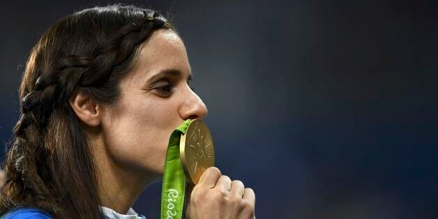 2016 Rio Olympics - Athletics - Victory Ceremony - Women's Pole Vault Victory Ceremony - Olympic Stadium - Rio de Janeiro, Brazil - 20/08/2016. Ekaterini Stefanidi (GRE) of Greece kisses her gold medal. REUTERS/Dylan Martinez FOR EDITORIAL USE ONLY. NOT FOR SALE FOR MARKETING OR ADVERTISING CAMPAIGNS.