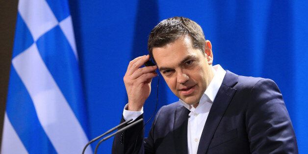 Alexis Tsipras, Greece's prime minister, adjusts his earpiece during a news conference at the Chancellery in Berlin, Germany, on Monday, March 23, 2015. Germany's Chancellor Angela Merkel is prepared for a wide-ranging conversation with Tsipras, as Greece braces for another payment deadline within days. Photographer: Krisztian Bocsi/Bloomberg via Getty Images