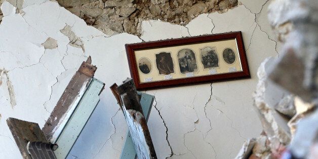 The interior of an house with old pictures still hanging on a wall is seen in Amatrice, following an earthquake, central Italy, August 25, 2016. REUTERS/Ciro De Luca