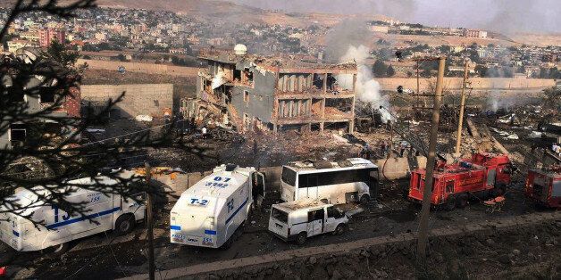 Smoke still rises from the scene after Kurdish militants attacked a police checkpoint in Cizre, southeast Turkey, Friday, Aug. 26, 2016, with an explosives-laden truck, killing several police officers and wounding dozens more, according to reports from the state-run Anadolu news agency. The attack struck the checkpoint some 50 meters (yards) from a main police station near the town of Cizre, in the mainly-Kurdish Sirnak province that borders Syria. Turkish authorities have put a temporary ban on distribution of images relating to Friday's Cizre attack within Turkey. (DHA via AP)