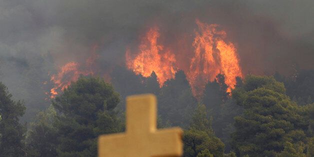 A fire burns over the Galataki Monastery near the village of Limni on the island of Evia, about 160kilometers (100 miles) north of Athens on Monday, Aug. 1, 2016. Nearly 200 firemen, assisted by water-dropping aircraft, fire engines and volunteers, are fighting a large forest fire that has raged through the Greek island of Evia for the past three days. (AP Photo/Thanassis Stavrakis)