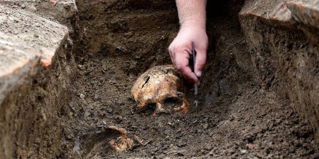An archaeologist works over an uncovered skeleton at the Viminacium site, around 100km east from Belgrade, Serbia August 8, 2016. Picture taken August 8, 2016. REUTERS/Djordje Kojadinovic