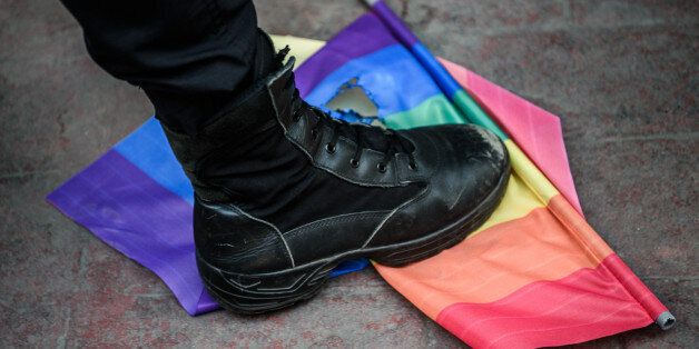 TOPSHOT - A Turkish anti-riot police officer steps on a rainbow flag during a rally staged by the LGBT community on Istiklal avenue in Istanbul on June 19, 2016.Turkish riot police fired rubber bullets and tear gas to break up a rally staged by the LGBT community in Istanbul on June 19 in defiance of a ban. Several hundred police surrounded the main Taksim Square -- where all demonstrations have been banned since 2013 -- to prevent the 'Trans Pride' event taking place during Ramadan. / AFP / OZAN KOSE (Photo credit should read OZAN KOSE/AFP/Getty Images)