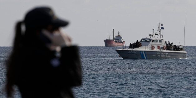 A coastguard vessel with refugees approaches the coastal Cretan port of Ierapetra, Greece, in front of a crippled freighter carrying hundreds of refugees trying to migrate to Europe on, Thursday, Nov. 27, 2014. The ship, whose 750 passengers are mostly Syrians, including children, women and elderly men, suffered engine failure 70 nautical miles off Ierapetra on Tuesday. The migrants will be given temporary shelter at an Ierapetra indoor basketball stadium. (AP Photo/Petros Giannakouris)