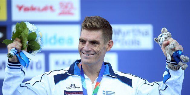 Bronze medallist Greece's Spyridon Gianniotis celebrates on the podium after the men's 10 km open water swimming event at the 2015 FINA World Championships in Kazan on July 27, 2015. AFP PHOTO / ROMAN KRUCHININ (Photo credit should read ROMAN KRUCHININ/AFP/Getty Images)