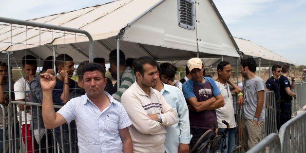 FILE - In this file photo taken on Monday, June 13, 2016, migrants who live in the Hellenikon refugee and migrant camp in Athens wait to register for asylum. A government official in Athens on Wednesday, Aug. 3, 2106 said to the Associated Press that there is no sign yet that a deal between the European Union and Turkey to stop migrants coming to Europe has faltered since the attempted military coup in the country. (AP Photo/Petros Giannakouris, File)