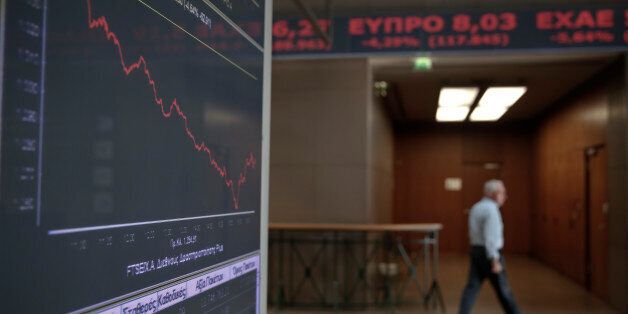 An employee walks past a screen showing a tumbling index at the Athens Stock Exchange on Wednesday Oct. 15, 2014. Concerns that the Greek government could collapse next year, putting its bailout program in danger, caused a massive sell-off in the country's stock and bond markets on Wednesday, with the main stock index down 9.8 percent. The plunge follows a loss of 5.7 percent the previous day and brings the stock market to its lowest level in 14 months. (AP Photo/Petros Giannakouris)