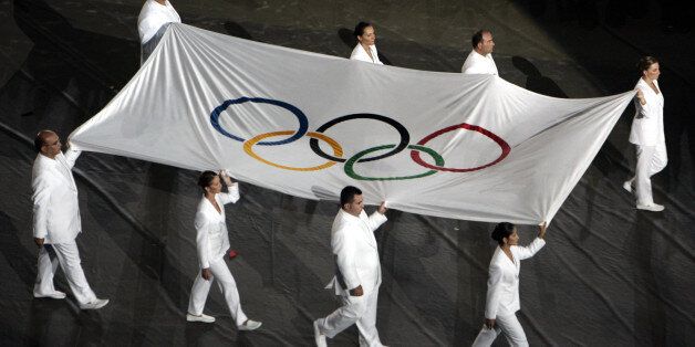The Olympic flag is carried during the closing ceremony of the Athens 2004 Olympic Games August 29, 2004. The next summer Olympic Games will be held in Beijing in 2008. REUTERS/Reinhard Krause CRB/AA