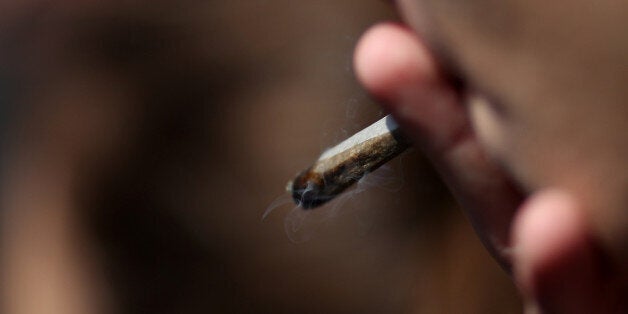 A man smokes a 'joint' during a demonstration to call for the legalisation of marijuana, on May 14, 2016 in Paris, France. / AFP / KENZO TRIBOUILLARD (Photo credit should read KENZO TRIBOUILLARD/AFP/Getty Images)