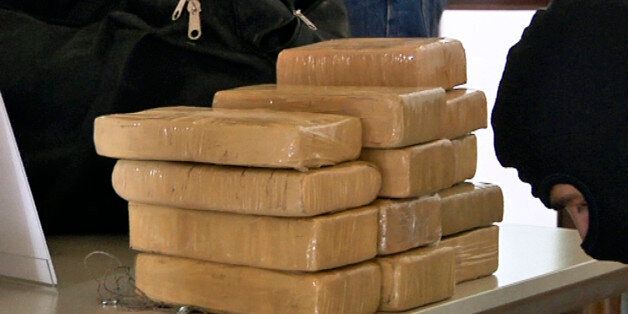 A still image from a video shows German police officers in balaclavas placing packages of cocaine on a table during a presentation to the media in Berlin, August 19, 2011. Germany has seized a huge haul of cocaine on Thursday in what the customs office described on Friday as its largest ever strike against drug smuggling. German newspapers reported that 100 kilogrammes of cocaine being smuggled by sea from Panama was seized by authorities in the port of Bremerhaven. According to the reports, the authorities believed the smugglers wanted to bring a total of 650 kilogrammes of cocaine to Germany in three shipments. REUTERS/Reuters TV (GERMANY - Tags: CRIME LAW)