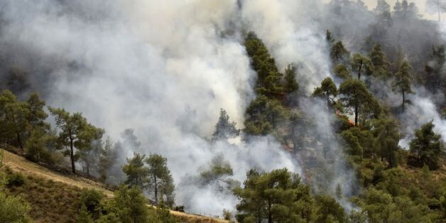 Smoke billows from a forest in the Cypriot village of Evrychou in the Troodos mountain area on June 20, 2016.Aircraft from Britain and Greece have joined Cypriot firefighters in a battle to control some of the worst forest fires to have hit the island in years, officials said. A fireman died in hospital of injuries suffered when the truck he was driving plunged down a cliff at Solea, at the foothills of the Troodos mountains, police said. / AFP / GEORGIO PAPAPETROU (Photo credit should read GEORGIO PAPAPETROU/AFP/Getty Images)