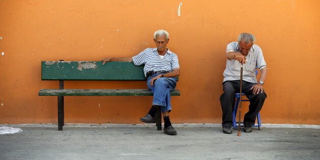 Two men sit on a bench in the village of Meyisti on the Island of Kastellorizo, Greece, July 4, 2015. It was on this island, that former Prime Minister George Papandreou announced in 2010 that Greece required a rescue package. If a 'No' in Sunday's referendum eventually takes Greece out of Europe's single currency, any