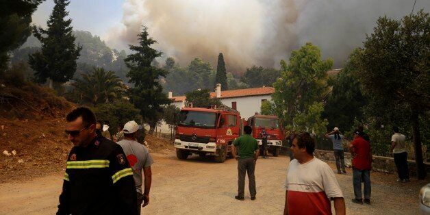 Local residents and firefighters try to save Galataki Monastery as a fire approaches the area, near the seaside village of Limni on the island of Evia, about 160 kilometers (100 miles) north of Athens on Monday, Aug. 1, 2016. Nearly 200 firemen, assisted by water-dropping aircraft, fire engines and volunteers, are fighting a large forest fire that has raged through the Greek island of Evia for the past three days. (AP Photo/Thanassis Stavrakis)