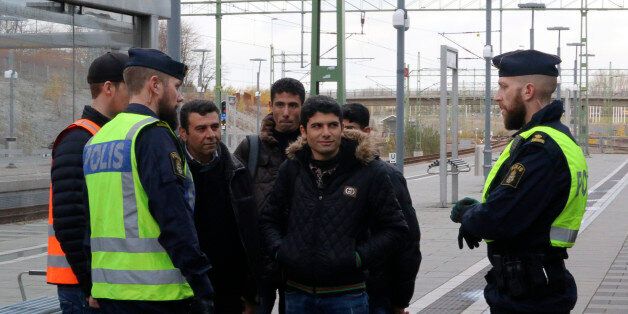 Swedish police officers speak to a group of people at the Hyllie train station near Malmo, Sweden, November 12, 2015. Swedish police began bordering trains on Thursday arriving from Denmark as they imposed the first large-scale border controls in two decades to deal with a refugee influx, but there were no signs the numbers of immigrants were slowing. REUTERS/Staff