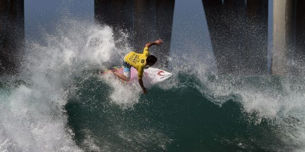 Mason Ho of Hawaii surfs beside the pier in his men's heat during the first round of the US Open of Surfing at Huntington Beach, California on July 25, 2016. The event celebrates it's 57th year beside the historic Huntington Pier, considered the birthplace of California's surfing culture. / AFP / Mark Ralston (Photo credit should read MARK RALSTON/AFP/Getty Images)