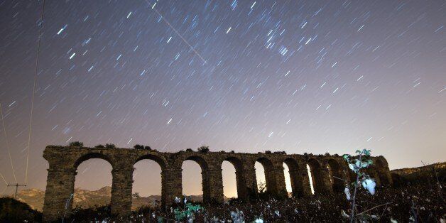ANTALYA, TURKEY - DECEMBER 14: Perseid meteor streaks across the sky above historical aqueduct at ancient city of Aspendos in Serik district of Antalya, Turkey on December 14, 2015. (Photo by Mustafa Ciftci/Anadolu Agency/Getty Images)