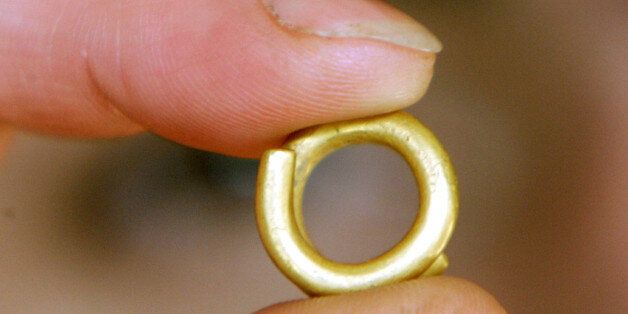 A Bulgarian National History Museum employee shows a golden ring in Sofia on October 21, 2004. The artifacts, which include beads, rings and many other objects, were found during an excavation at an Early Bronze Age village in Bulgaria, archaeologists announced on Thursday. The location of the site will be kept secret until the end of the excavation.