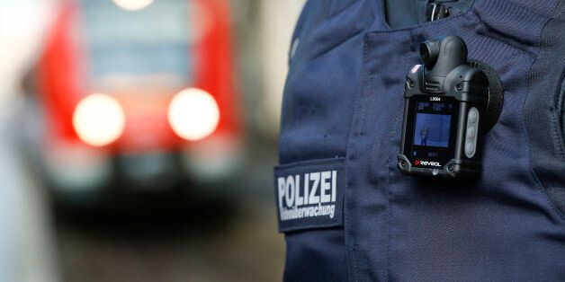 A train arrives as a federal police officer of Germany's Bundespolizei, wearing a so-called 'body-cam', patrols at the main railway station in Cologne, Germany February 3, 2016. Germany's Bundespolizei, who is in charge railways and airport security as well as the border control is performing a test with body-cams in Duesseldorf and Cologne, ahead of the upcoming carnival season. REUTERS/Wolfgang Rattay