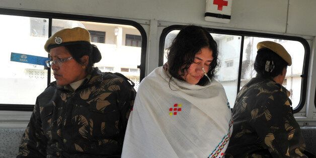 TO GO WITH India-unrest-Manipur-politics,FEATURE by Abhaya SrivastavaA policewoman escorts civil rights activist, Irom Sharmila Chanu (R) also known as the 'Iron Lady of Manipur' or 'Mengoubi' (meaning 'the fair one') is flanked by escorting police personnel as she sits inside an ambulance after attending a hearing at The Magistrate's Court in Imphal on February 22, 2012. For more than 11 years, Sharmila has refused food and water to back her demand for the withdrawal of the special powers wielded by -- and according to critics widely abused by -- the security forces. AFP PHOTO/Manjunath KIRAN (Photo credit should read Manjunath Kiran/AFP/Getty Images)