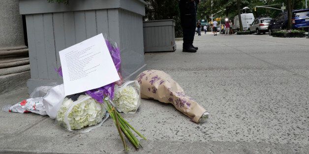Flowers are left at a makeshift memorial for the victims of the Nice attack as a police officer with the antiterrorism unit stands guard outside the French consulate in New York, Friday, July 15, 2016. A Frenchman of Tunisian descent drove a truck through crowds celebrating Bastille Day along Nice's beachfront, Thursday night, killing scores of people, many of them children. (AP Photo/Mary Altaffer)