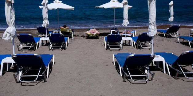 PETRA, GREECE - 20 JULY. Tourists enjoy a sun on an almost empty beach in Petra town on July 20, 2016 on Lesvos island Greece. The increase in refugees arriving on the island of Lesvos last year has seriously effected tourism, with the number of tourists falling more than 70% this year so far. (Photo by Milos Bicanski/Getty Images)