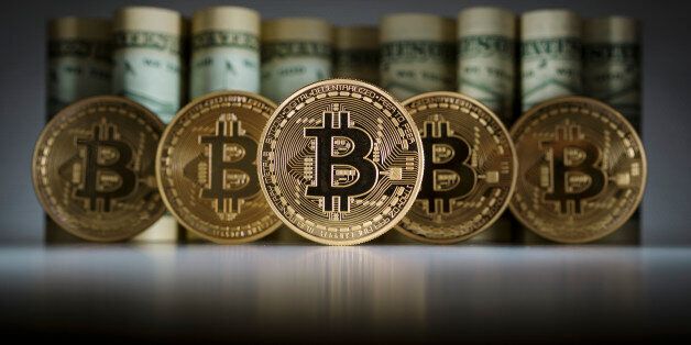 BERLIN, GERMANY - FEBRUARY 15: In this photo illustration model Bitcoins standing in front of Dollar bills on February 15, 2016 in Berlin, Germany. (Photo Illustration by Thomas Trutschel/Photothek via Getty Images)