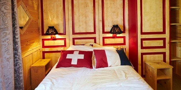 A bed lies directly across the French-Swiss border, with the head of the bed in Switzerland and the foot of the bed in France at the Hotel Arbez in Les Rousses April 23, 2014. Switzerland will vote on November 30 on an initiative from the group Ecopop which proposes a cap on the number of immigrants. The group says it is motivated by concerns about a lack of living space exerting too much pressure on the land and natural resources, rather than by opposition to foreigners. It proposes limiting immigration to just 0.2 percent of the resident population, equivalent to 16,000 people per year. This would represent a cut of more than 75 percent in annual net immigration from current levels. In Switzerland's system of direct democracy, any voter can trigger a referendum by collecting 100,000 signatures within 18 months. Picture taken April 23, 2014. REUTERS/Denis Balibouse (FRANCE - Tags: POLITICS ELECTIONS SOCIETY IMMIGRATION TPX IMAGES OF THE DAY)