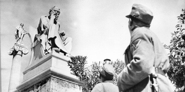 German troopers in their field grey uniforms look up at two ancient Greek statues on the Acropolis in Athens, Greece on June 15, 1941 during World War II. The statue in front is of Greek philosopher Socrates. (AP Photo)